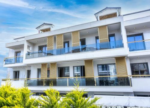 un edificio de apartamentos con balcones y árboles en Evitel Luxury Living en Hanioti