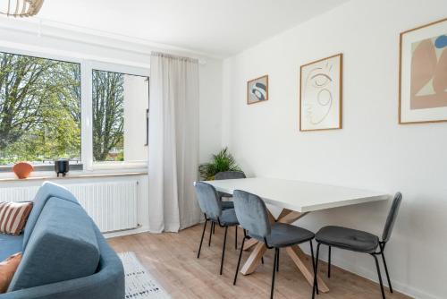 a white living room with a table and chairs at FLATLIGHT - Shiny Apartment - Balcony - Central - Kitchen in Hildesheim