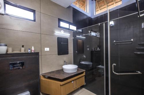 a bathroom with a sink and a glass shower at Coconut Cove Varkala in Varkala