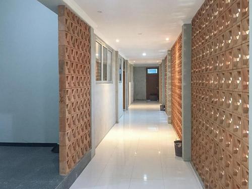 a hallway of a building with a brick wall at RedDoorz near Wisata Paribendo Lawang in Lawang
