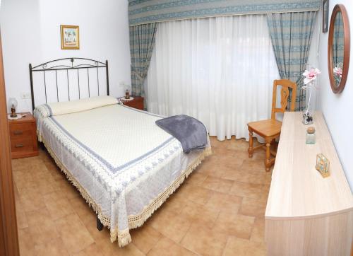 ビラガルシーア・デ・アロウサにあるA Rosaledaのベッドルーム1室(ベッド1台、テーブル、窓付)
