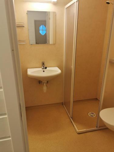 a bathroom with a sink and a shower with a mirror at Lunde Camping in Aurland