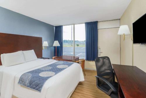 ステーツビルにあるDays Inn by Wyndham Statesvilleの大きなベッドと机があるホテルの部屋