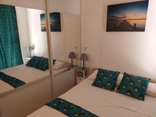 a small bedroom with two beds and a mirror at Porteo - Les Terrasses du Port in Centuri