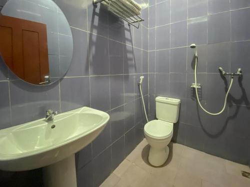 a bathroom with a sink and a toilet and a mirror at RedDoorz @ Merauke City Center in Merauke