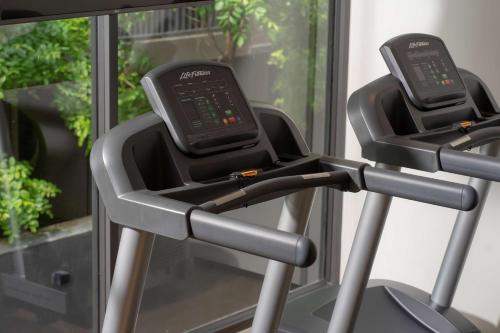 two treadmills on a treadmill in front of a window at Bayphere Hotel Pattaya JC in Na Jomtien