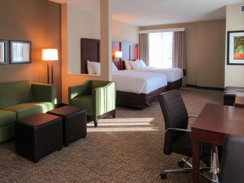 Comfort Suites في سامرفيل: غرفة فندقية بسرير وطاولة وكراسي