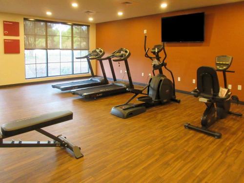a gym with several exercise bikes and a flat screen tv at Comfort Suites Summerville North in Summerville