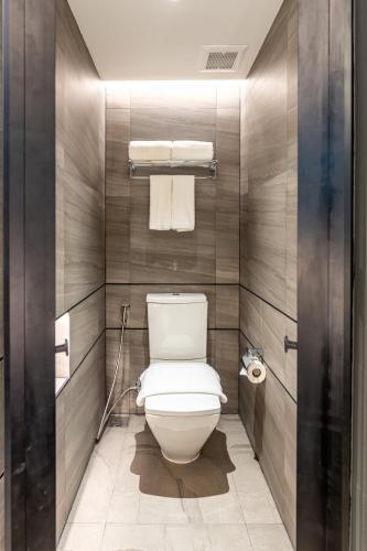 a bathroom with a white toilet in a room at Bayphere Hotel Pattaya JC in Na Jomtien
