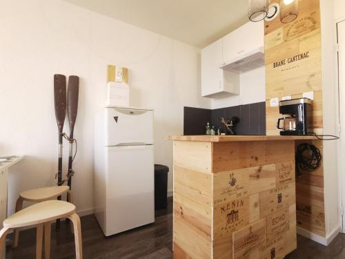 a small kitchen with a white refrigerator and a counter at Le Carlton - Superbe Appartement - Accès direct plage - Terrasse Vue mer in Leucate
