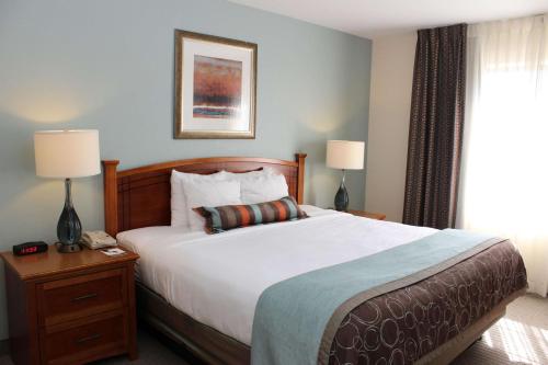 Un dormitorio con una gran cama blanca y una ventana en Sonesta ES Suites Portland Vancouver 41st Street, en Vancouver