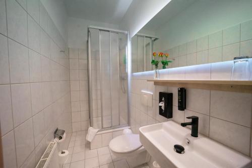 a bathroom with a shower and a sink and a toilet at Feel Good Hotel in Chemnitz