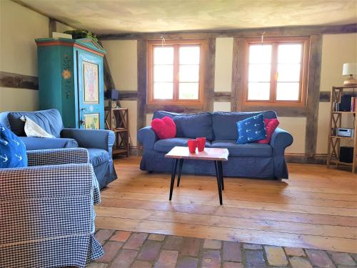 a living room with two blue couches and a table at Fischerhus Lütt Hauke 75 qm Annerose in Altwarp
