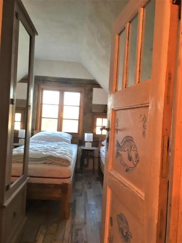 a bedroom with a bed and a wooden door at Fischerhus Lütt Hauke 75 qm Annerose in Altwarp