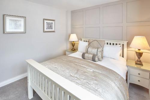een witte slaapkamer met een wit bed en 2 lampen bij Host & Stay - Sandling Court in Middlesbrough