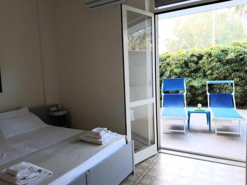 a bedroom with a bed and two blue chairs at Residence Le Barchette in San Cataldo