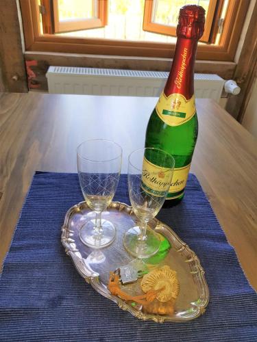 a bottle of wine and two glasses on a table at Fischerhus Lütt Hauke 75 qm Annerose in Altwarp