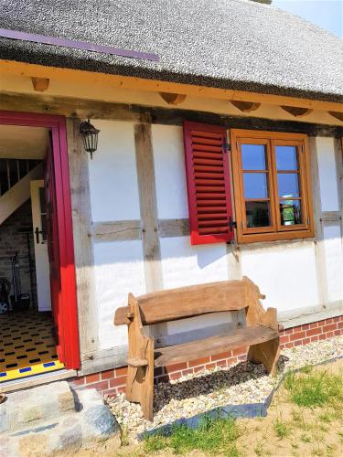 a wooden bench sitting outside of a house at Fischerhus Lütt Hauke 75 qm Annerose in Altwarp