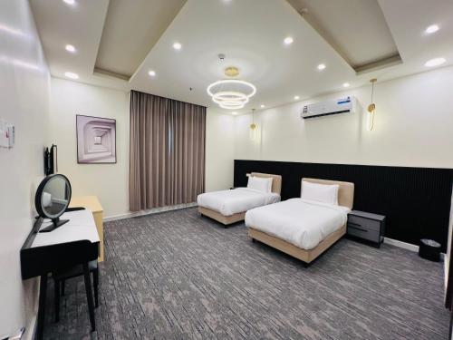 ein Hotelzimmer mit 2 Betten und einem Klavier in der Unterkunft Falcon Grand Hotel in Ras al-Hadd