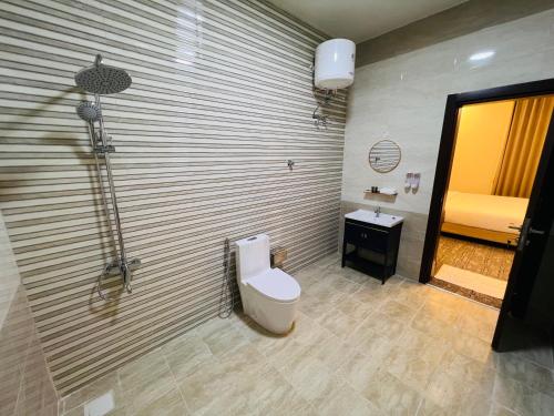 a bathroom with a toilet and a sink at Falcon Grand Hotel in Al Ḩadd