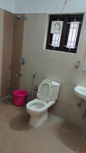 a bathroom with a toilet and a sink and a window at Royal Serene Villas in Ooty