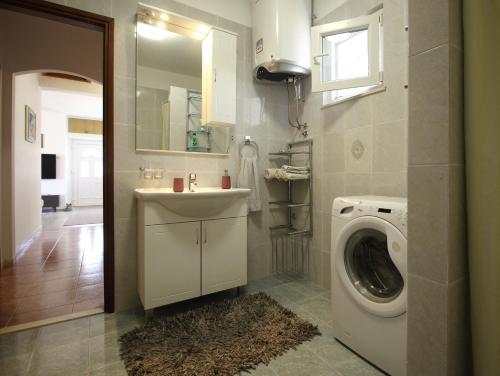 a bathroom with a sink and a washing machine at Apartment Marita in Čilipi