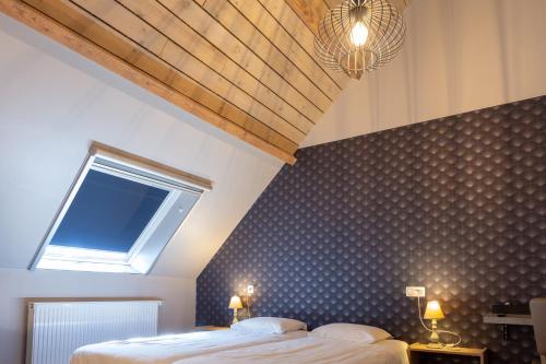 a bedroom with a bed and a window in it at Oud Gemeentehuis in Poelkapelle