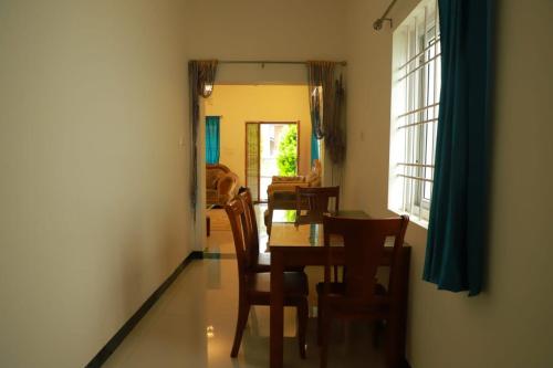 a dining room with a table and chairs and a window at Hotel Aradhana Inn in Yercaud