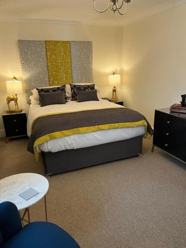1 dormitorio con 1 cama, 2 mesas y 2 lámparas en The Masons Arms Hotel, en Bridgend