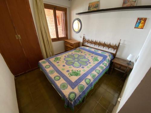 een slaapkamer met een bed met een quilt bij Apartamentos Neptuno Altamar in Alcossebre