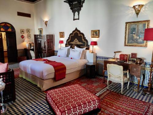 a hotel room with a large bed and a desk at Riad Le Calife in Fès