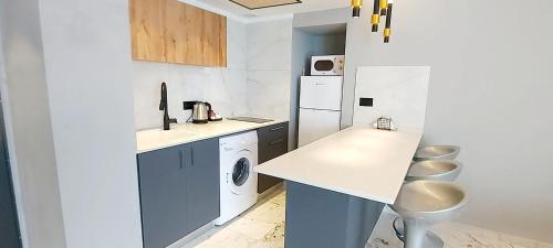 a white kitchen with a sink and a washer and dryer at 7 Hotel Apartment Short Time TLV BAT YAM in Bat Yam