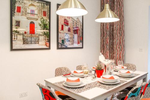 a dining room with a white table and chairs at QLiving Central New Apartments Gzira Sliema Promenade in Il-Gżira