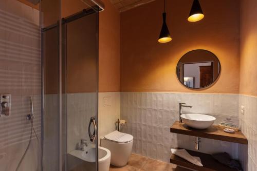 a bathroom with a sink and a toilet and a mirror at Tenuta Il Cicalino in Massa Marittima