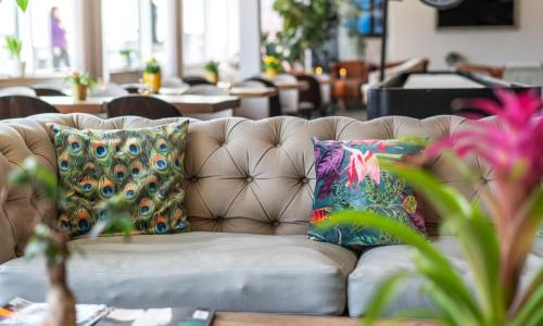 a couch with two colorful pillows on it at Thon Partner Hotel Kungsbron in Stockholm