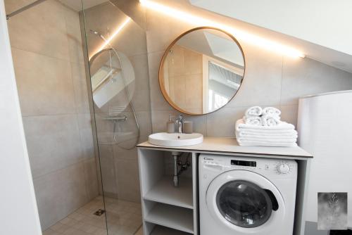 a bathroom with a washing machine and a mirror at COME2rest - Smilga in Juodkrantė