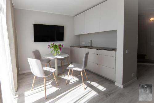 a living room with a table and chairs and a tv at COME2rest - Smilga in Juodkrantė