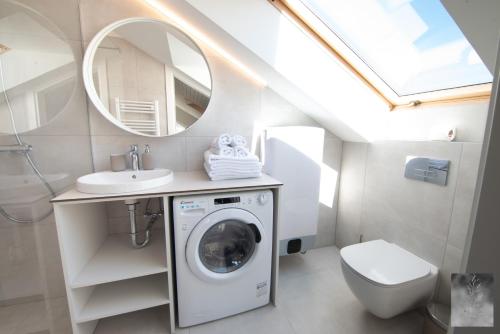 a bathroom with a washing machine and a sink at COME2rest - Smilga in Juodkrantė