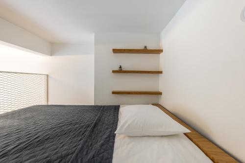 a bedroom with a bed and shelves on the wall at Small Cozy two-level Apartments 9 in Tallinn