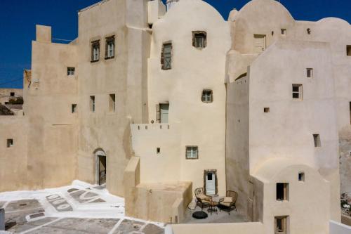 a building in the desert with a table in front of it at Exi Castle Suites in Emporio Santorini