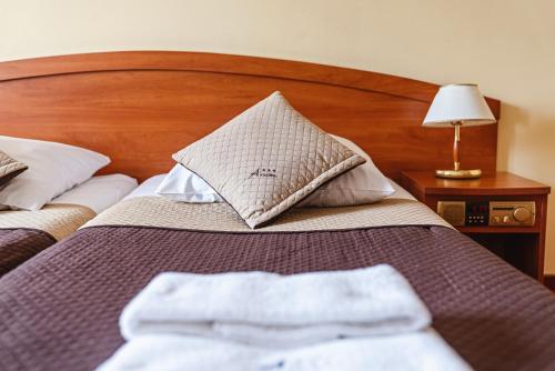a bed with two towels sitting on top of it at Kompleks Antałówka Termy & Med in Zakopane