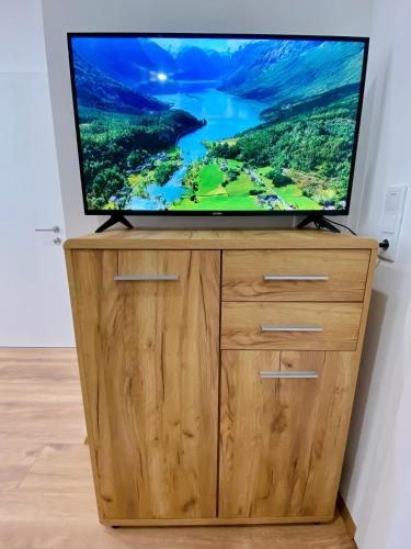 a flat screen tv sitting on top of a wooden dresser at Apartment Katrin im Zentrum in Bad Ischl