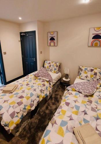 een kamer met 2 bedden en een bank bij Green Lantern, Private En-suite Double Bedroom in Aveley