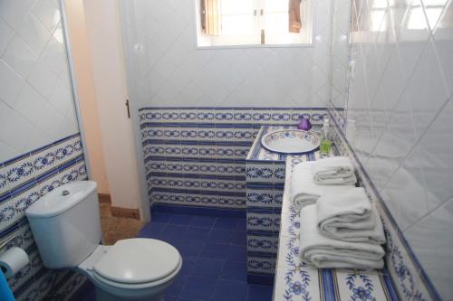 a blue and white bathroom with a toilet and a sink at Casa Turquesa in Sintra