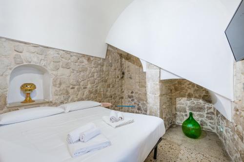 a bedroom with a bed in a stone wall at Scicli Albergo Diffuso in Scicli