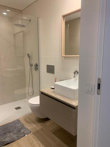 een badkamer met een wastafel, een toilet en een douche bij Golden Coast Residence in Portimão