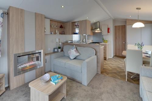 a living room with a couch and a tv and a kitchen at The Lakes Rookley in Rookley