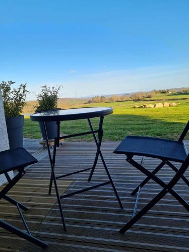 una mesa de picnic y 2 sillas en una terraza en Chambres d'hôtes La Ganivelle, en Servant