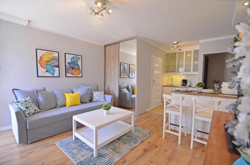 a living room with a couch and a kitchen at Apartamenty Bryza in Świnoujście