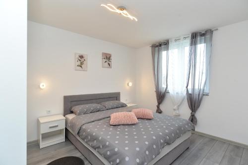 a bedroom with a bed with two pillows on it at House Fazana 2154 in Fažana